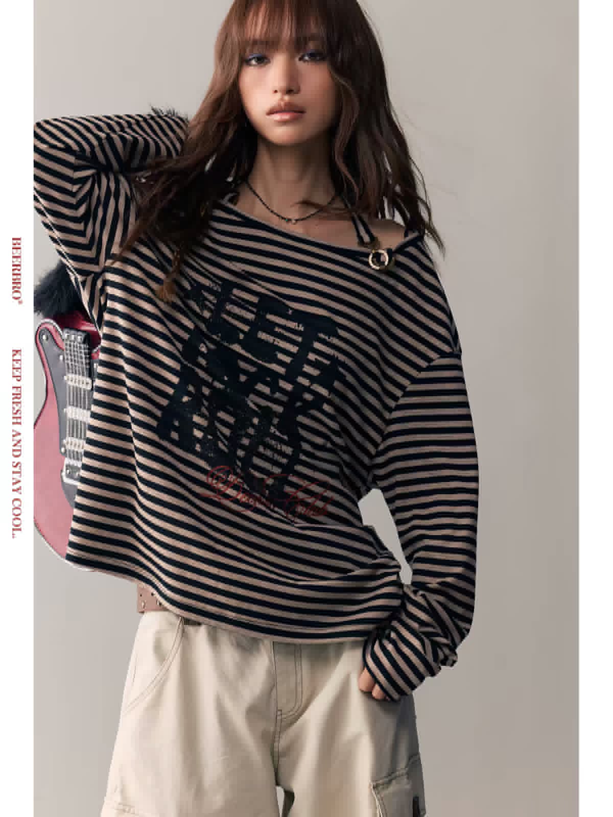 Model wearing a black-and-beige striped graphic long-sleeve top with cargo-style pants