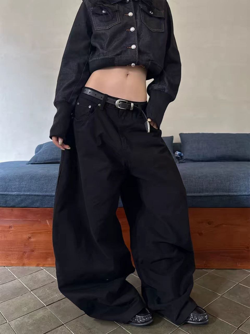 Model wearing a black cropped jacket and wide-leg cargo-style pants
